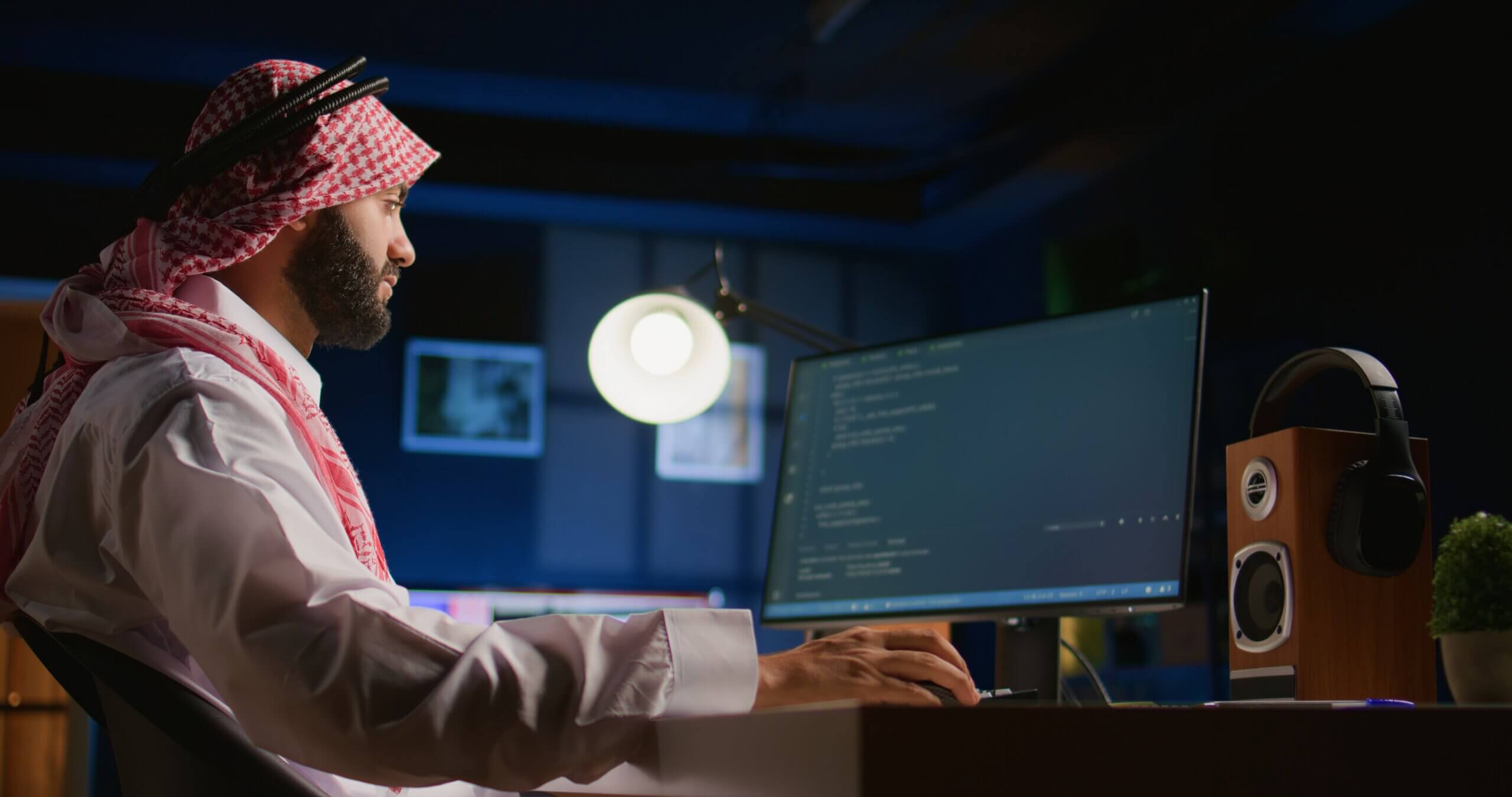 Arab technician writing script code on computer screen inputting commands on terminal. Middle Eastern teleworking employee at home working on fixing company internal database errors